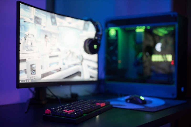A sleek gaming monitor displaying both code and a game, showcasing its dual functionality.